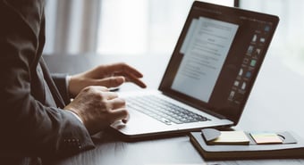 Man reading a report on a laptop