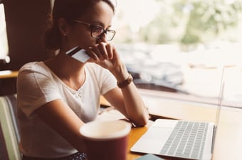 Woman uses credit card on her laptop